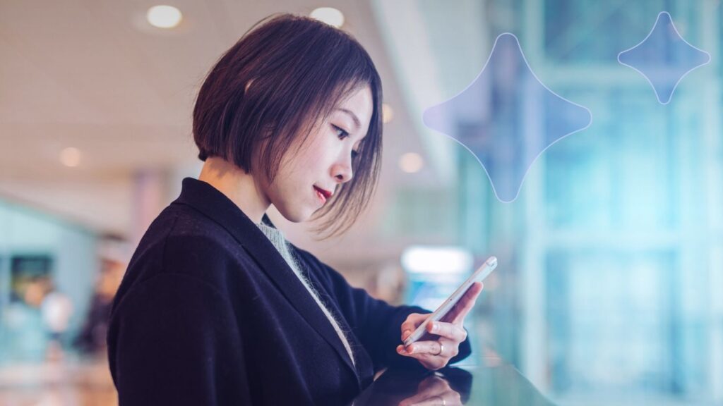 Woman looking at her smartphone inside building near window